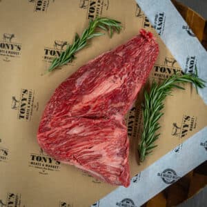 Tri-tip roast being sliced after grilling—a top lesser-known grilling cut